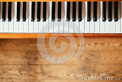 Vintage wooden piano. Keys in the foreground, wooden floor with text space in the blurry background Stock Photo