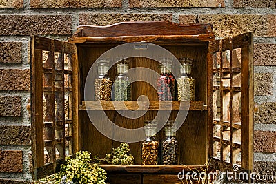 Vintage Wooden Spice Rack or Storage Cabinet and six glass bottles Stock Photo