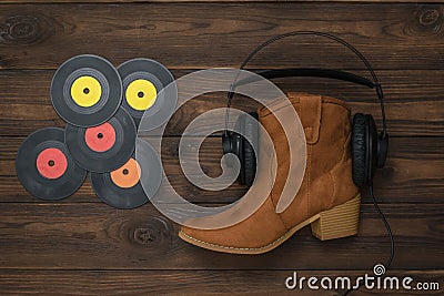 Vinyl discs, boots, headphones on a wooden background. Stock Photo