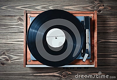 Vinyl player with plates on a wooden table. Entertainment 70s. Listen to music. Stock Photo