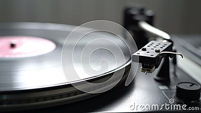 The vinyl record on DJ turntable record player close up. The rotating plate and stylus with the needle close-up neutral Stock Photo