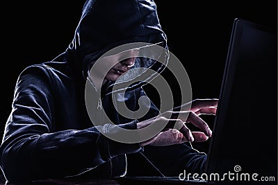 Violation of intellectual property rights concept. Hacker in a hood. Stock Photo