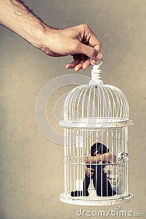 Violence against women. Woman in cage. Deprivation of liberty. Stock Photo