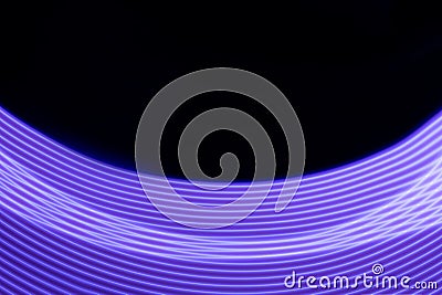 Violet shining neon smooth stripes of light on black background. Abstract background with energy line Stock Photo