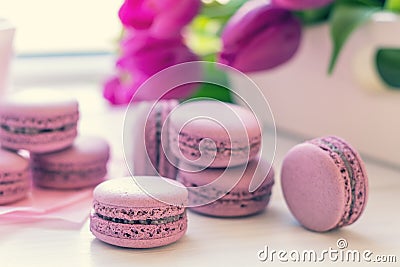 Violet sweet delicious macaroons and fresh tulips Stock Photo