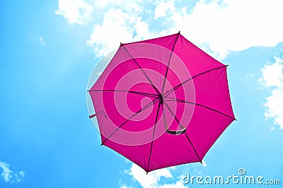 Violet umbrella flying on blue sky Stock Photo