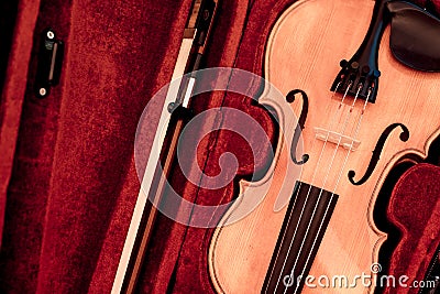 Violin and bow in dark red case. Close up view of a violin strings and bridge Stock Photo