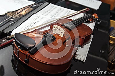 Violin lying on piano. Stock Photo