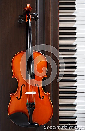 A violin next to the piano keyboard Stock Photo