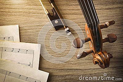 Violin pegbox and bow with sheet music on table vintage Stock Photo