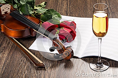 Violin, rose, glass of champagne and music books Stock Photo