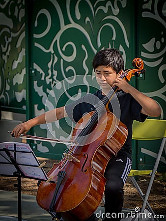 Violin student playing at Davis farmers market Editorial Stock Photo