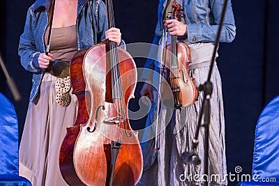 Violin and violoncello in women hands on concert Stock Photo