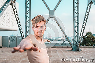 Virabhadrasana, yoga posture executed by a young red-haired athlete outdoors, copy space Stock Photo