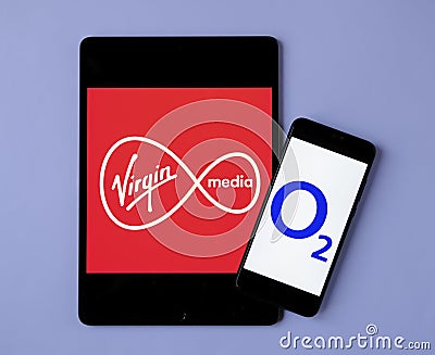 Virgin Media and O2 Telefonica logos on the mobile devices. Concept for potential merger of the two telecom companies Editorial Stock Photo