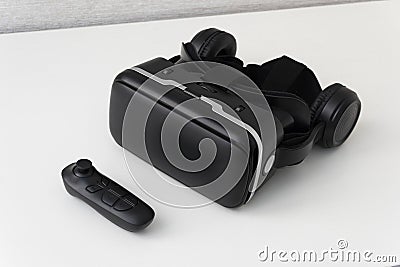 Virtual reality helmet and a joystick on white background. Black modern glasses for watching 360 degree videos for a Stock Photo