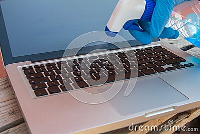 Virus sanitization on the computer keyboard with blue spray jet screen and sanitizing wipe Stock Photo