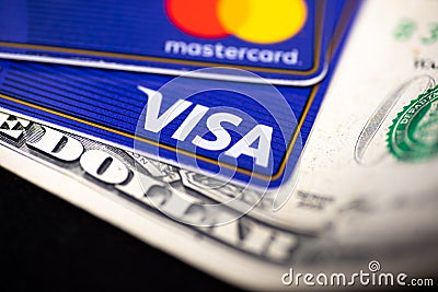 Visa card and Mastercard credit cards on top of a dollar bill Editorial Stock Photo