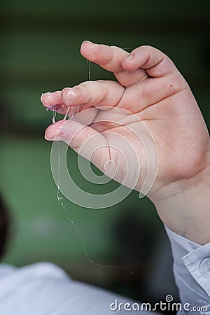 Viscous transparent substance on the fingers of a chemist in the laboratory Stock Photo