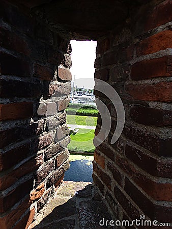View through the shooting hole of the Muiderslot castle wall, Muiden Castle in the Dutch town Muiden, Holland, the Netherlands Editorial Stock Photo