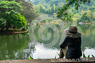 visitor contemplating nature by a calm lake within the resort Stock Photo