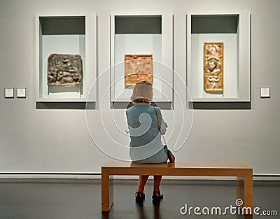 Visitor looking art object in museum Editorial Stock Photo
