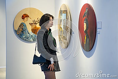 Visitor looking at paintings in an art gallery. Editorial Stock Photo
