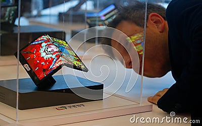 Visitor looking at CSOT foldable smartphone by LTC shown at Mobile World Congress 2019 in Barcelona Editorial Stock Photo