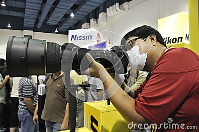 A visitor testing Nikon's camera and lens Editorial Stock Photo