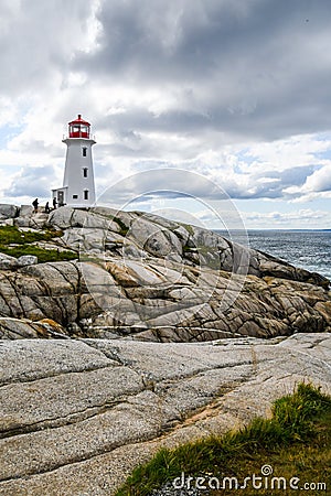 Visitors Climbing to Peggy's Cove Lighthouse Stock Photo