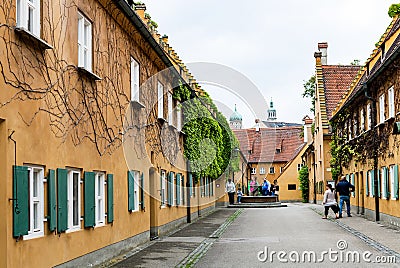 Visitors near well in Fuggerei housing in Augsburg Editorial Stock Photo