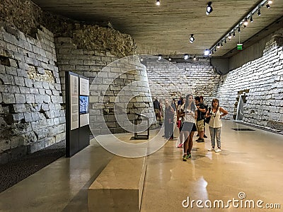 Visitors study a portion of the medieval Louvre as preserved in the modern museum, Paris, France Editorial Stock Photo