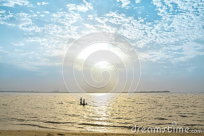 Visitors are swimming at a beach and sunrise in the background Editorial Stock Photo