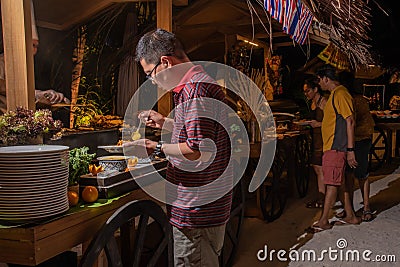 Visitors taking food during the international cuisine dinner outdoors setup at the island restaurant Editorial Stock Photo
