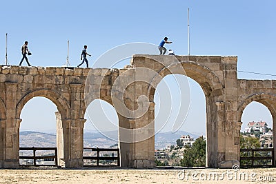 Visitors to the ancient site of Jerash in Jordan walk along the remains of the arched Hippodrome. Editorial Stock Photo