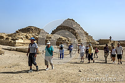 Visitors to Giza in Egypt walk past the Pyramids of the Queens Editorial Stock Photo