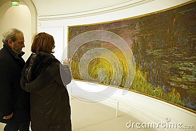 Visitors view Monet's giant water lily oils Editorial Stock Photo