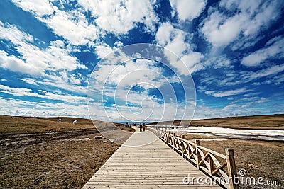 Visitors and Blue sky white clouds Frozen river Yellow grass in Bayanbulak in Spring Editorial Stock Photo
