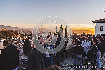 Visitors watching the sunset and observing the Alhambra Palace from Mirador de San Nicolas, Granada, Spain Editorial Stock Photo