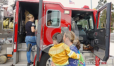 Vista, CA / USA - October 13, 2018: People interact with firefighters and explore trucks during fire prevention month open house. Editorial Stock Photo