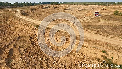 Vista do grande caminhão vermelho vazio que move sobre uma trilha arenosa perto da máquina escavadora amarela no deserto ou nas d vídeos de arquivo Vista do grande caminhão vermelho vazio que move sobre uma trilha arenosa perto da máquina escavadora amarela no deserto ou nas d vídeos de arquivo