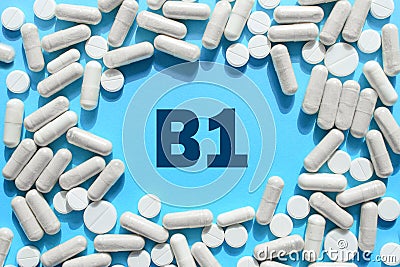 Vitamin B1 text in white capsules frame on blue background. Pill with thiamine, thiamin. Dietary supplements and medication Stock Photo