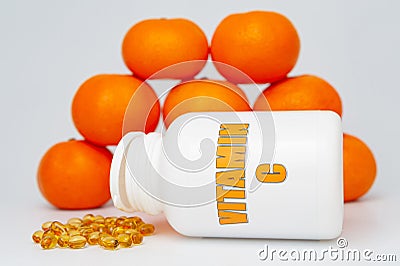 Vitamin C bottle with scattered softgel and oranges. Isolated on white background. Healthy immune system Stock Photo