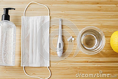 Vitamin D, vitamin C and zinc pills on wooden table with face mask, sanitizer, lemons, flat lay Stock Photo