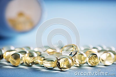 Vitamin D pills spilled out of a bottle on a table Stock Photo