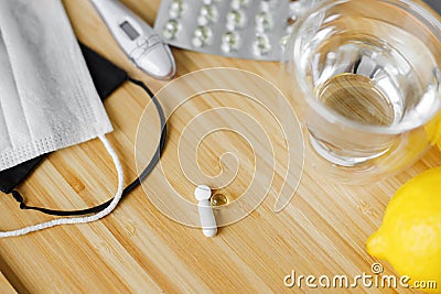 Vitamin D, vitamin C and zinc pills on wooden table with face mask, lemons. Boost immune system Stock Photo