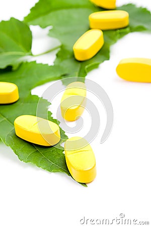 Vitamin pills over green leaves Stock Photo