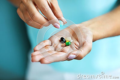 Vitamins And Supplements. Female Hand Holding Colorful Pills Stock Photo