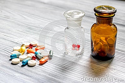 Vitamins and supplements. Pills and pill bottle on grey wooden table background Stock Photo