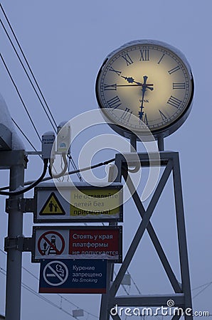 Luminous clock with Roman numerals and information signs Editorial Stock Photo